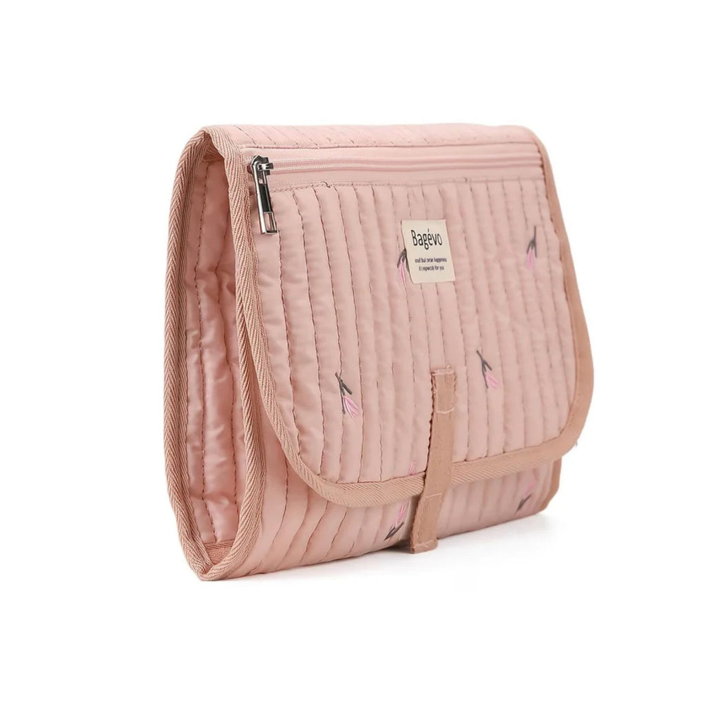 Side view of compact folded quilted baby changing clutch showing slim travel profile and storage caddy thickness - Pink Tulip available from Senso-Blanky