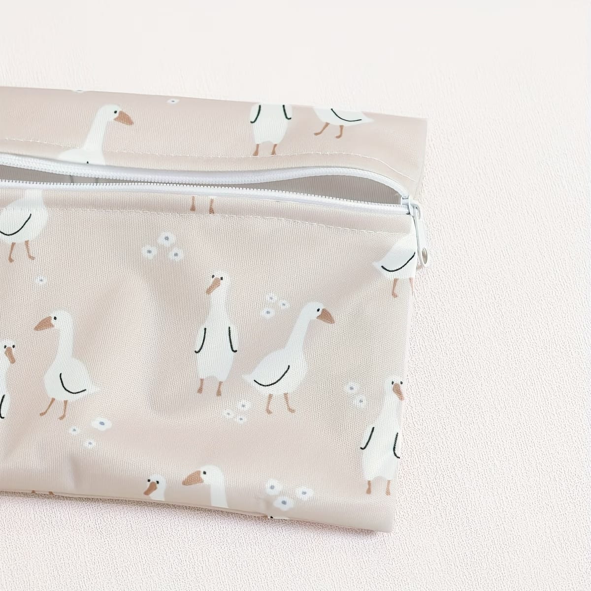 close-up of reusable waterproof wet bag set in dusty pink goose motif - available from Senso-Blanky