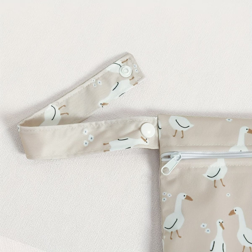 close-up of reusable waterproof wet bag detachable strap in dusty pink goose motif - available from Senso-Blanky