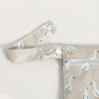 close-up of reusable waterproof wet bag detachable strap in dusty pink goose motif - available from Senso-Blanky