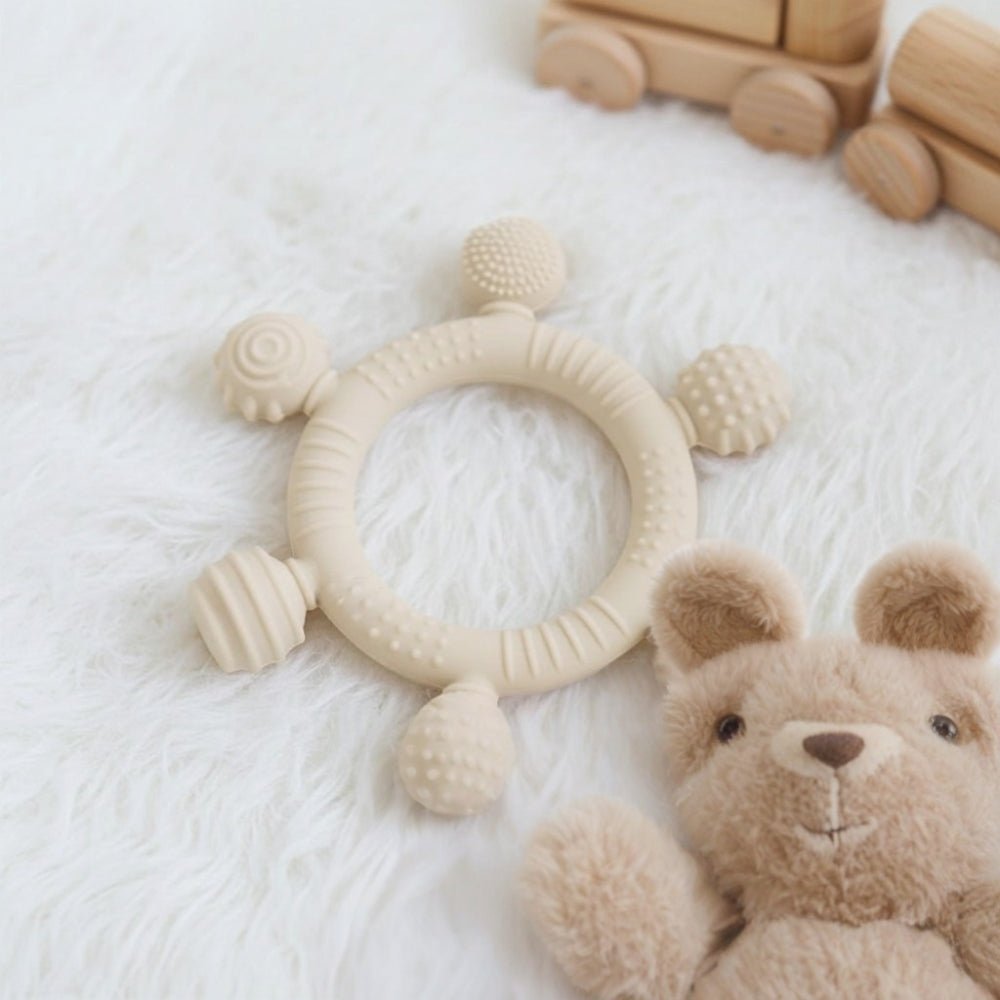 6-Ball silicone sensory teether ring and infant gum soother in beige for babies 3 months and older, showing multiple unique textures.