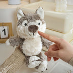 Adult hand holding up the 17cm soft grey plush wolf toy showing its compact size and fluffy texture, available from Senso-Blanky