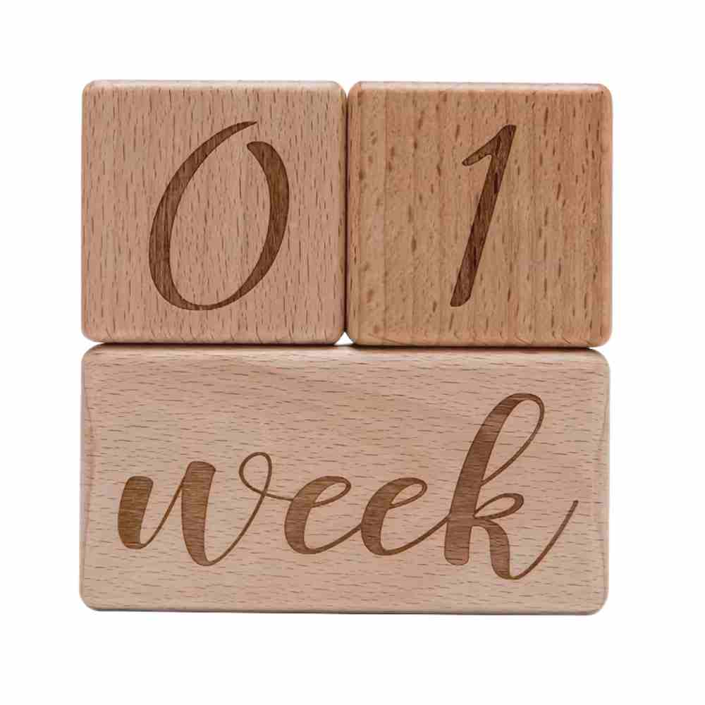 Close-up of crisp engraved lettering and smooth unfinished wood grain texture on baby milestone blocks	Premium Hardwood Texture & Lettering