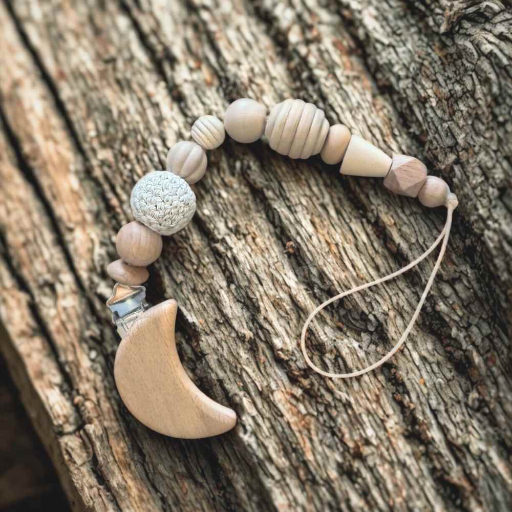 Senso-Grip premium baby dummy clip beautifully displayed in its retail packaging, resting on natural tree bark background for a rustic, organic feel. Handcrafted sensory pacifier chain by Senso-Blanky South Africa.