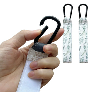 Close-up of durable Green Leaves printed adjustable Velcro strap and heavy-duty metal carabiner clip being opened for stroller - Available from Senso-Blanky